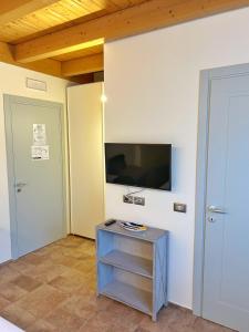 a room with a tv on the wall and a table at Agrestia azienda agricola in Bertinoro