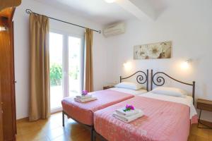 1 dormitorio con 2 camas y ventana grande en Spiros Saint Stephanos, en Ágios Stéfanos