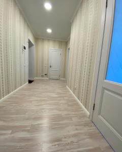 an empty hallway with a white door and a window at APARTAMENT в мкр Батыс-2 в комфортном ЖК Нектар in Aktobe