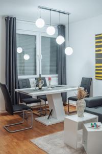 a dining room with a white table and chairs at Apartman Arija - Self Check In in Osijek