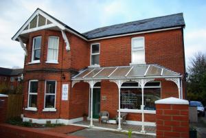 a red brick house with an awning on it at Old Church House in Newport