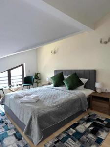 una camera da letto con un grande letto con cuscini verdi di Pamporovo Rhodopi Pearl Apartments - Private Apartments a Pamporovo