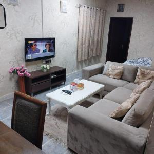 sala de estar con sofá y TV en العين الهيلي مصباح ب 7 en Al Ain