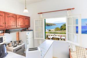 cocina con ventana y vistas al océano en Evanna House in Saint Stephanos, en Ágios Stéfanos