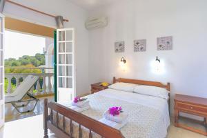 1 dormitorio con 1 cama y balcón en Evanna House in Saint Stephanos, en Ágios Stéfanos