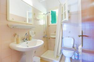 y baño con lavabo, aseo y espejo. en Evanna House in Saint Stephanos, en Ágios Stéfanos