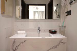 a white sink in a bathroom with a mirror at لحظات للشقق المخدومة in Jeddah +83 photos