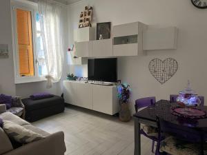 een woonkamer met een tv en een tafel bij Casa Delle Sirene 5 minuti mare Boccadasse in Genua