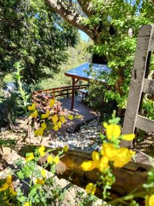 uma mesa de piquenique num deque debaixo de uma árvore em Cabaña de montaña Ruca Calel em San Carlos de Bariloche