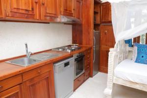 a kitchen with a sink and a stove at Tembo Beach Cottage , Ocean Beach Drive in Malindi +21 photos