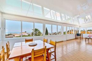a dining room with a table and some windows at Villa Marite - 4 bed/ 2 bath - own private pool in Fuengirola