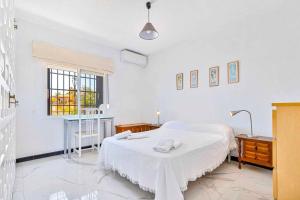 a white bedroom with a bed and a window at Villa Marite - 4 bed/ 2 bath - own private pool in Fuengirola +33 photos