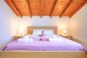 a bedroom with a large bed with towels on it at Penelope Stone House in Kalami
