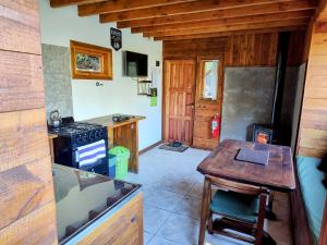 a small kitchen with a table and a stove at Cabaña de montaña Ruca Calel in San Carlos de Bariloche