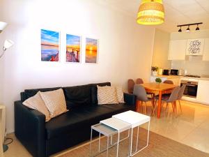 a living room with a black couch and a table at Maravilloso Bungalow in Gran Alacant +15 photos