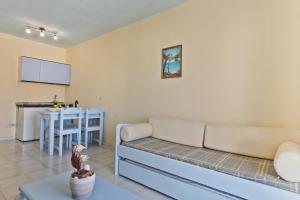 a living room with a couch and a table at Regina Studios & Hotel in Karpathos