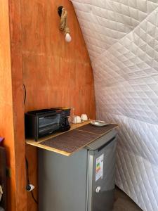 a small kitchen with a microwave and a counter at Milenaria Glamping in Panguipulli