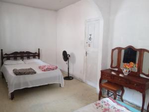 1 dormitorio con cama, espejo y tocador en Quarto Duplo en Vitória