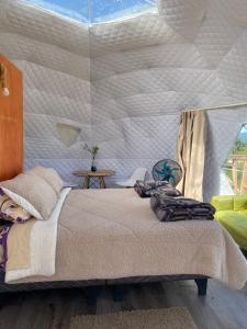 een slaapkamer met een groot bed en een tent bij Milenaria Glamping in Panguipulli