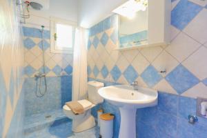 baño azul y blanco con lavabo y aseo en Irena Saint Stephanos, en Ágios Stéfanos