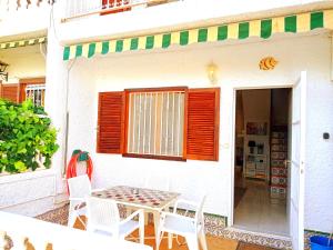 eine Terrasse mit einem Tisch und Stühlen außerhalb eines Hauses in der Unterkunft Maravilloso Bungalow in Gran Alacant