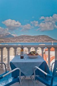 a table with a plate of fruit and a bottle of wine at Regina Studios & Hotel in Karpathos Town