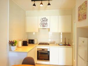 a kitchen with white cabinets and a stove top oven at Maravilloso Bungalow in Gran Alacant