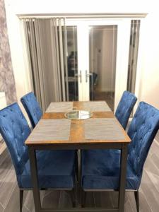 a wooden table with blue chairs around it at Brook Meadow Entire Home Stay in Birmingham