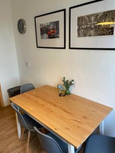 una mesa de madera en una habitación con sillas y fotografías en Stylisches Appartement "Johanna" in Weißenfels en Weißenfels