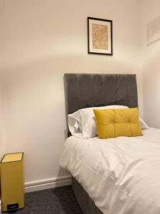 a bedroom with a bed with a yellow pillow at Brook Meadow Entire Home Stay in Birmingham