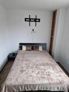 - une chambre dotée d'un lit avec une croix sur le mur dans l'établissement Casa din Izvor, à Tărlungeni