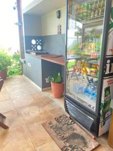 a refrigerator with drinks inside of it in a kitchen at Noah Hostel & Chale in São Miguel do Gostoso