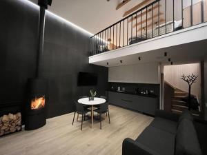 a living room with a table and a fireplace at WakeMālpils brīvdienu mājas in Mālpils