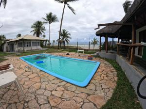 una piscina in un cortile accanto a una casa di Condomínio Terra Pura a Ilhéus Altre 15 foto