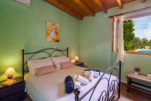 a bedroom with a bed with towels on it at Marguerita House in Georgoutsátika +22 photos