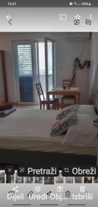 een slaapkamer met een bed en een tafel en stoelen bij Villa Palfi in Jezera