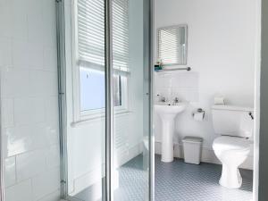 een witte badkamer met een toilet en een wastafel bij Love Lane - Cosy & Modern City Centre Guest Suite in Canterbury