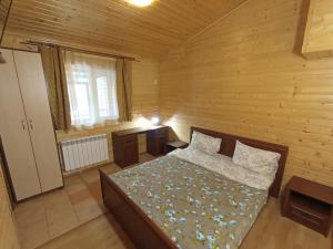 ein Schlafzimmer mit einem Bett in einem Holzzimmer in der Unterkunft Villa Leontiya in Schidnyzja