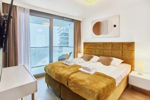 una camera da letto con un grande letto con una grande finestra di Wave Panorama Apartment - Sea View&SPA a Międzyzdroje