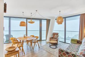 ein Wohnzimmer mit einem Tisch und Stühlen in der Unterkunft Wave Panorama Apartment - Sea View&SPA in Misdroy