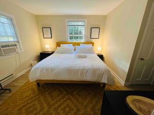 una camera da letto con un grande letto con lenzuola e cuscini bianchi di Lux 4 Bed Home w/ Parking Walk to Bethesda Metro! a Chevy Chase