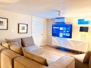 uma sala de estar com um sofá e uma televisão de ecrã grande em Lux 4 Bed Home w/ Parking Walk to Bethesda Metro! em Chevy Chase