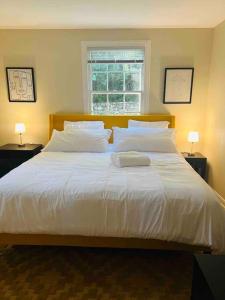 a bedroom with a large white bed with two lamps at Lux 4 Bed Home w/ Parking Walk to Bethesda Metro! in Chevy Chase