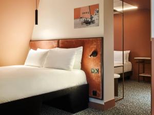 um quarto de hotel com uma cama e um espelho em TRIBE Hôtel Le Touquet em Le Touquet-Paris-Plage