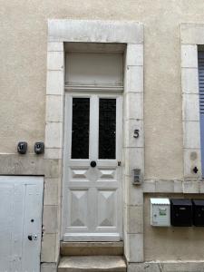 una porta bianca sul lato di un edificio di Charmant T2 plein centre ville et proche gare a Bourges