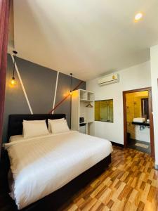 1 dormitorio con 1 cama blanca grande y suelo de madera en DE Hotel en Phnom Penh