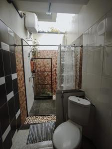 La petite salle de bains est pourvue d'une douche et de toilettes. dans l'établissement Villa Rumah Hijau Syariah, à Cihanjuang 1