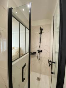 uma casa de banho com um chuveiro e uma porta de vidro em Maison Auguste em Paris