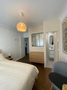 um quarto com uma cama e uma casa de banho com um lavatório em Maison Auguste em Paris