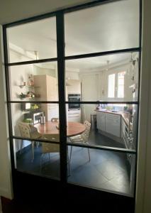 um quarto com uma mesa e uma cozinha através de uma janela em Maison Auguste em Paris